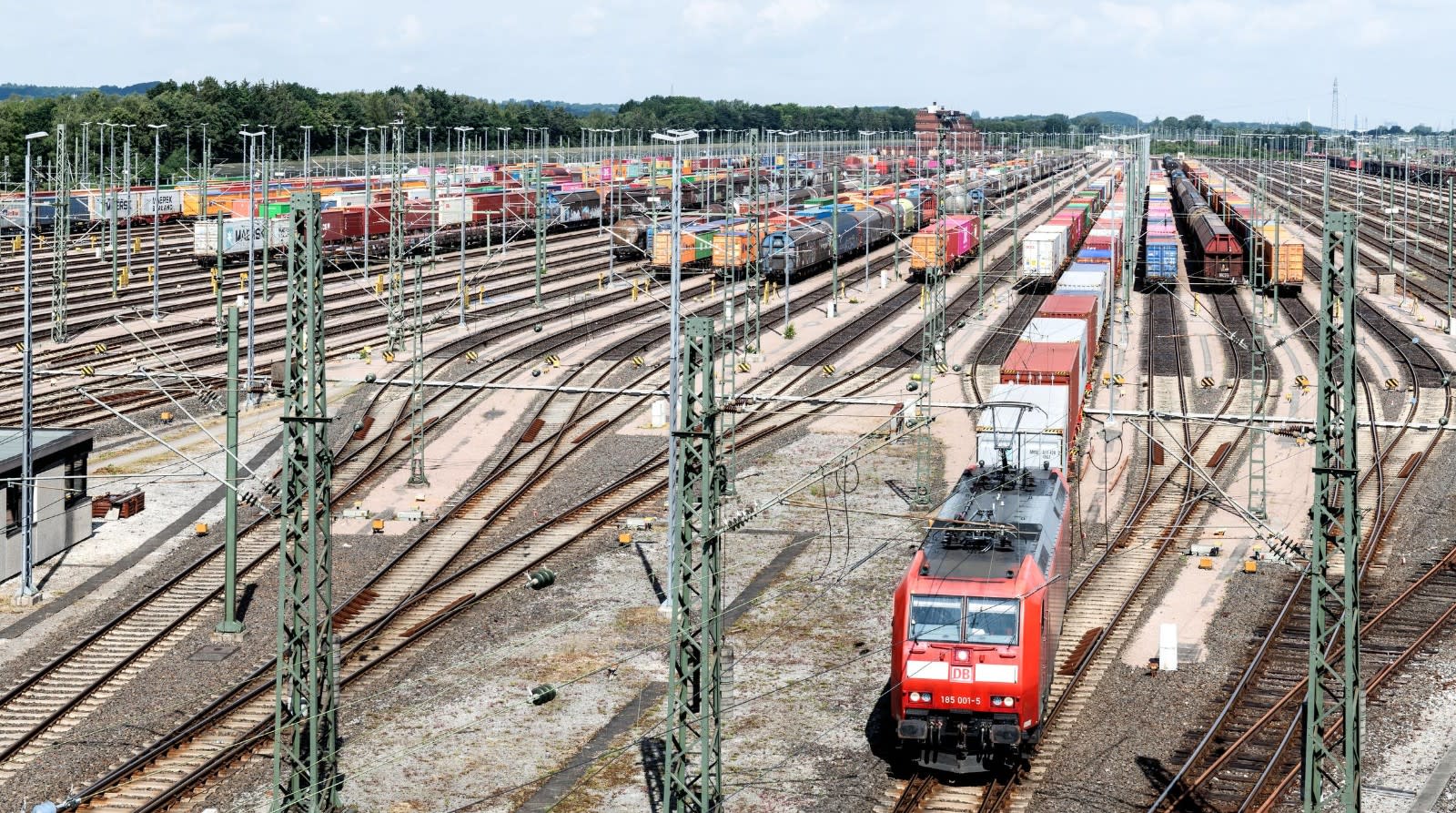 Seřaďovací nádraží s nákladními vagony a červenou lokomotivou