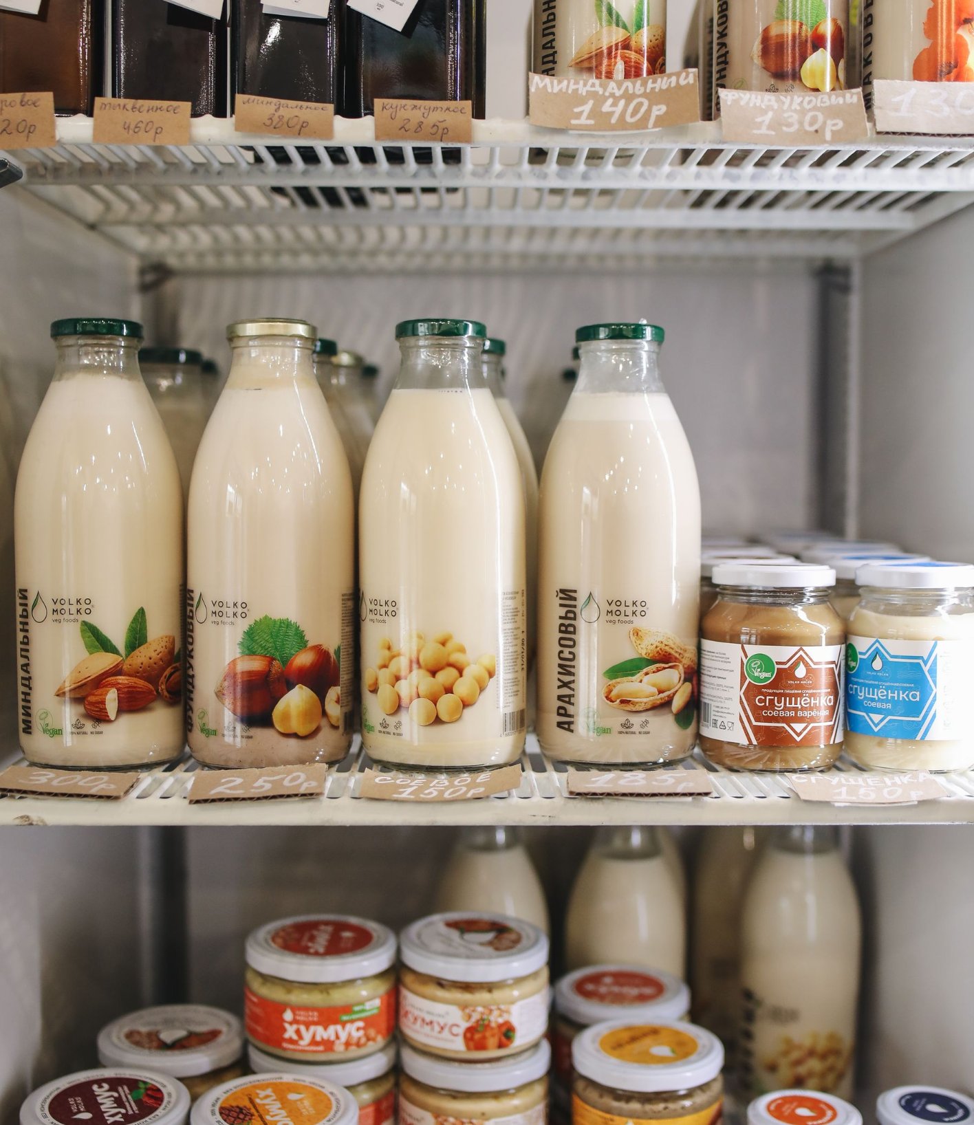 Chilled shelf with bottled milk drinks and jars