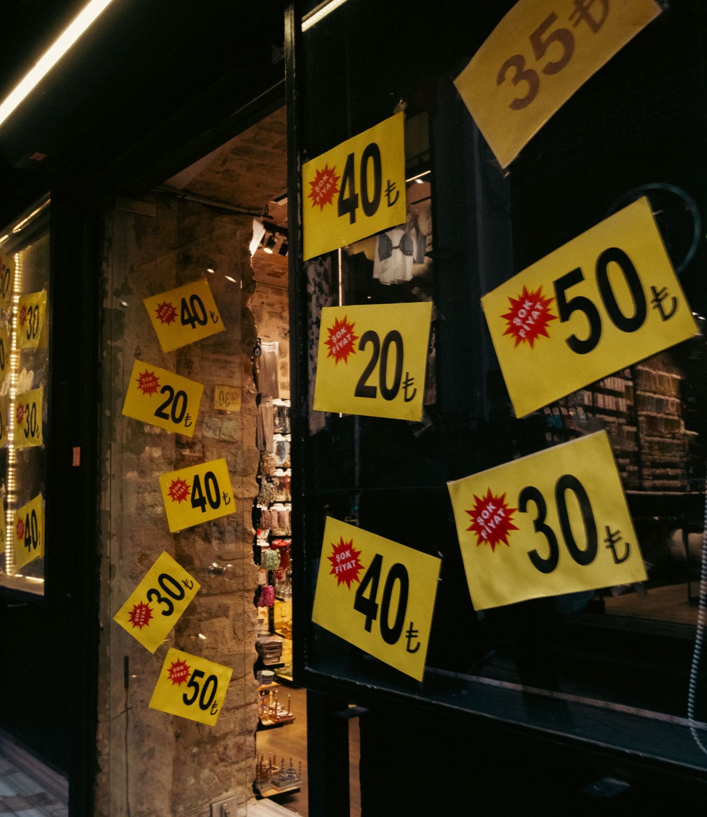Shop window with yellow markdown tags showing percentage discounts