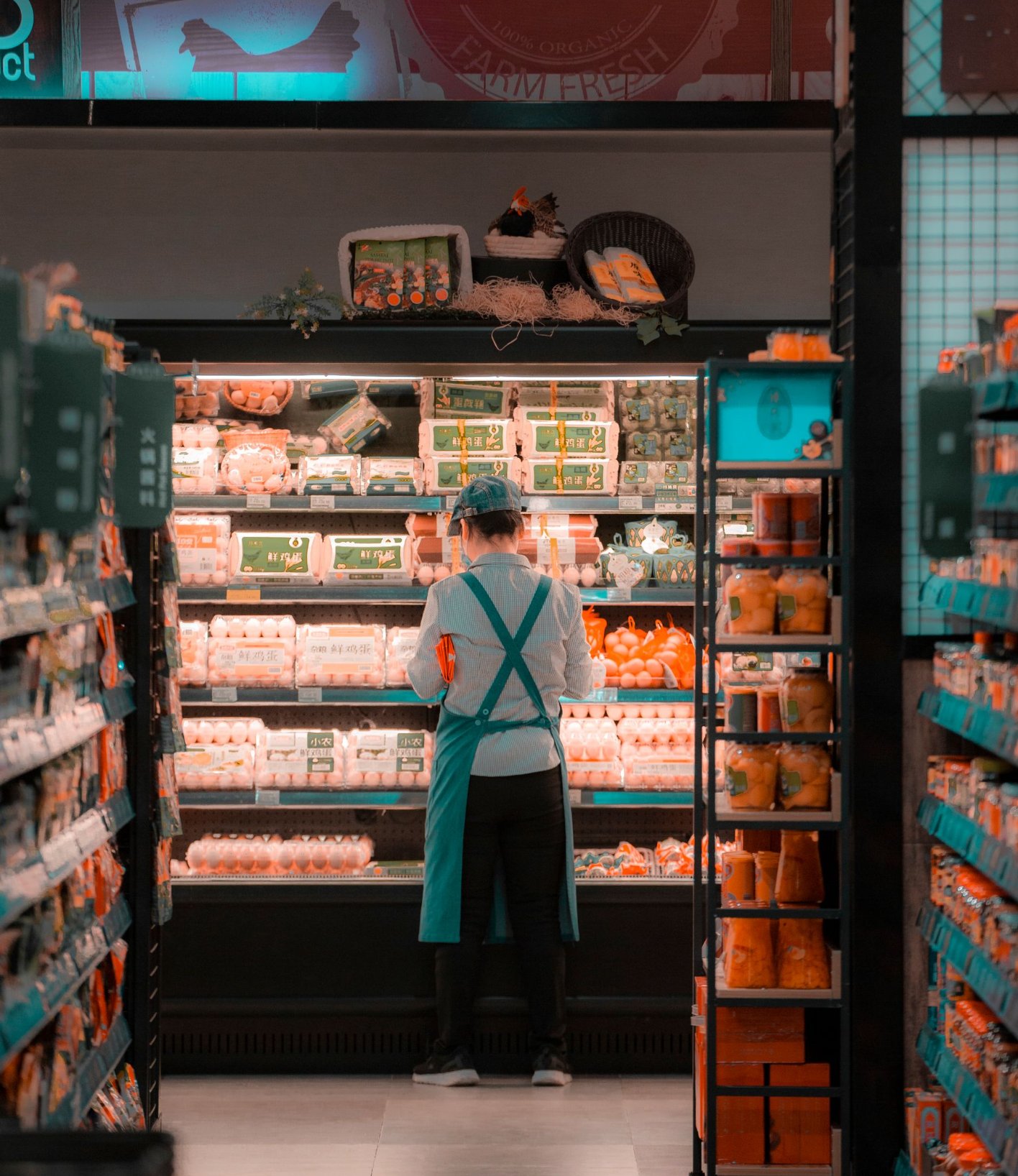 Store employee arranging products on a supermarket shelf